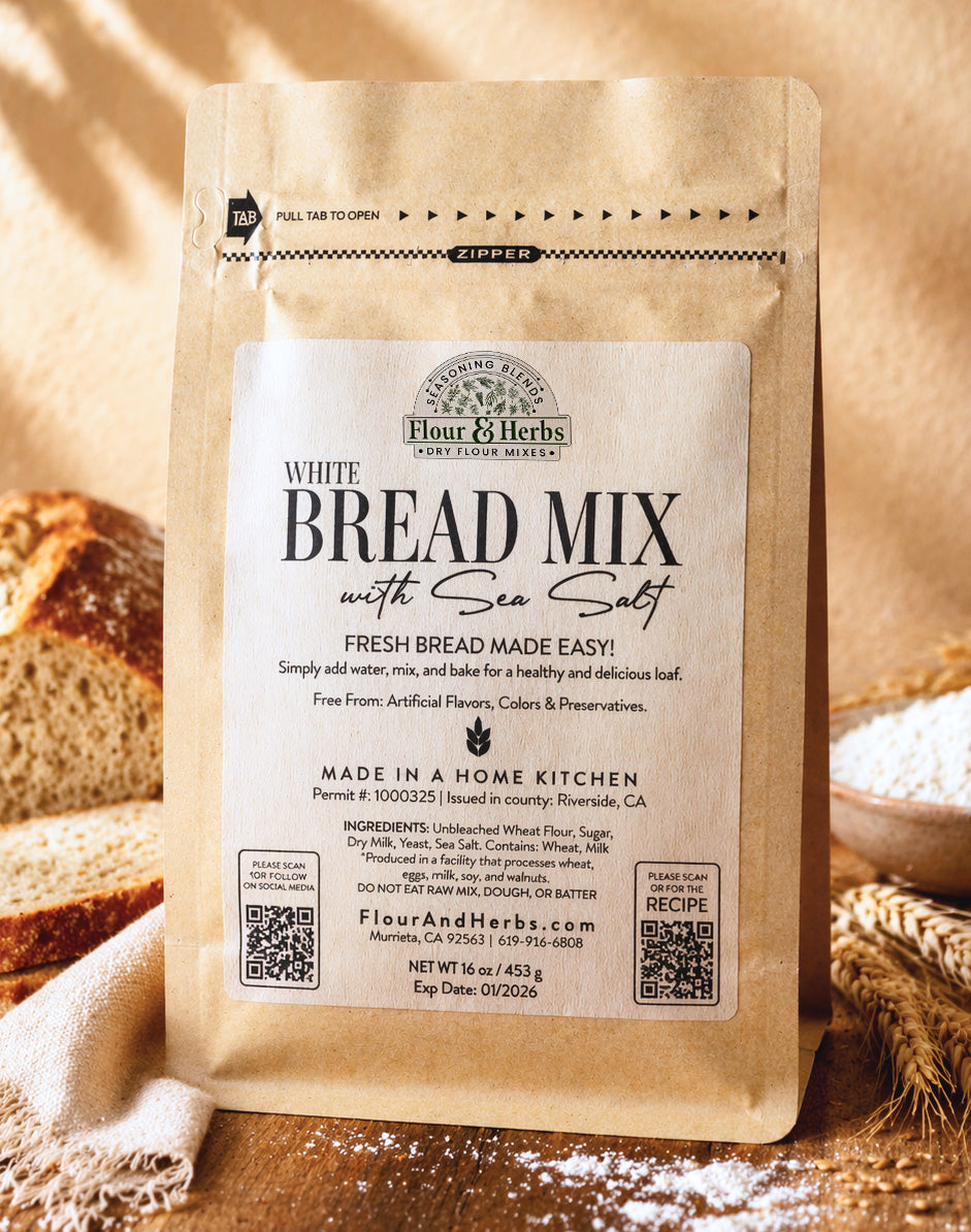 Flour & Herbs artisan Bread Mix with Sea Salt kraft pouch displayed with freshly baked bread, wheat stalks, and flour on a warm wooden surface